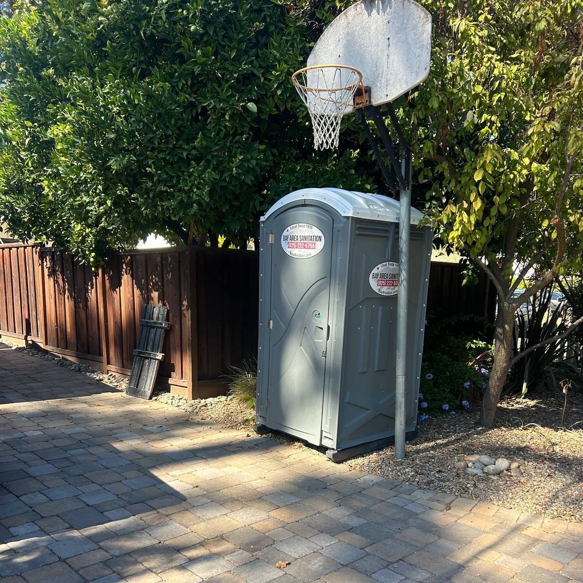Bay Area Sanitation portable toilet on a backyard paver patio, available for Blackhawk home projects