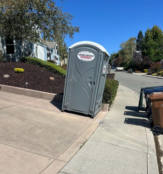 Standard porta potty on a residential sidewalk, available for home remodels in Vacaville
